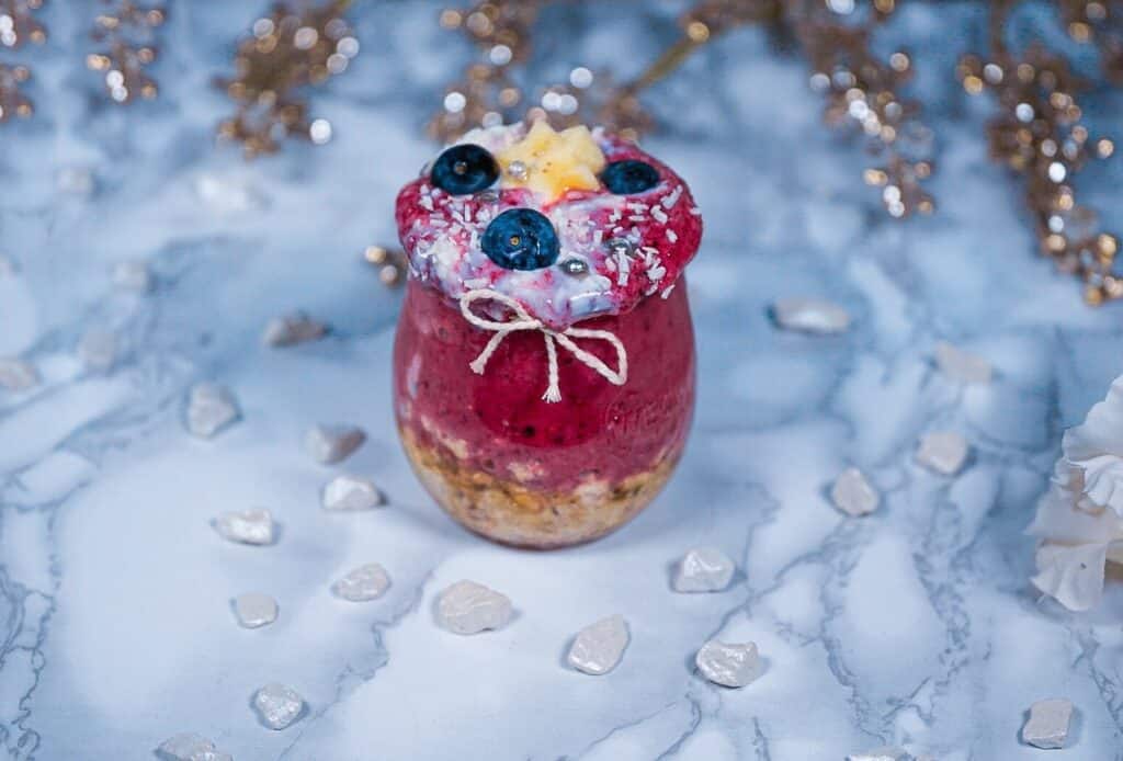 Beeren-Nicecream in Kombinatin mit gekochten Muesli. Zuerst wurden das Muesli, dann die Beeren-Nicecream in ein Gals gefuellt. Eine Beeren Nicecream ist wie ein Smoothie, jedoch mit einer dickeren Konsistenz. 