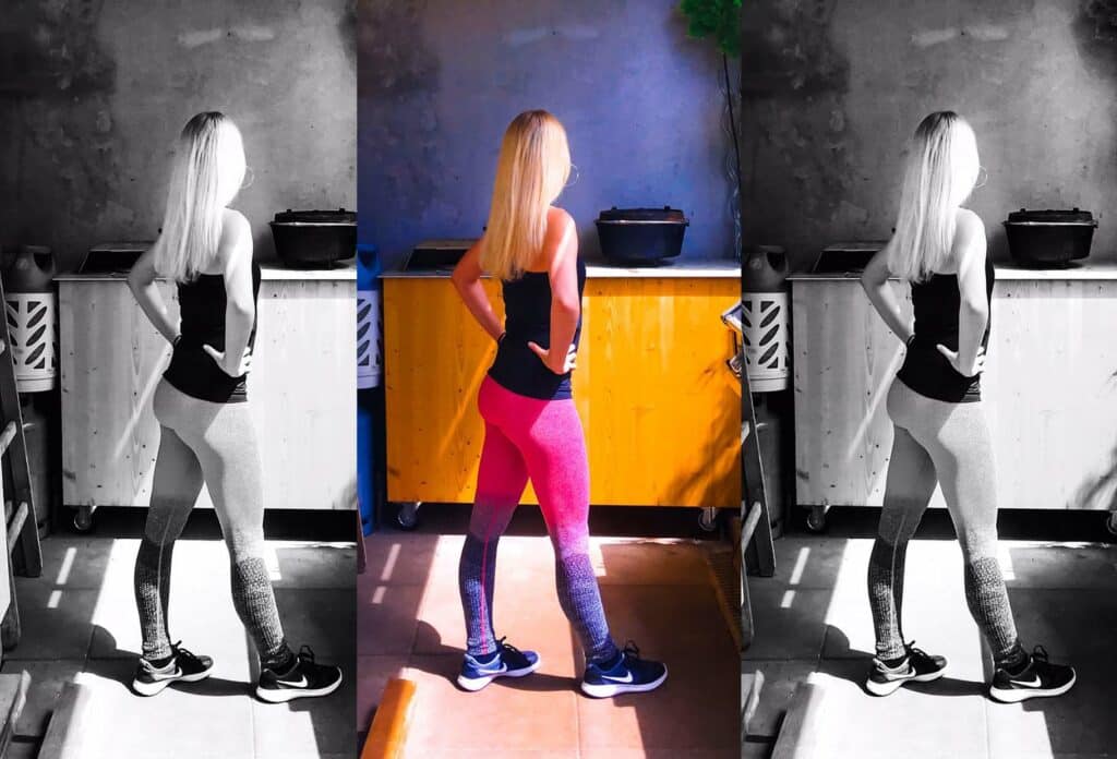 Schlanke blonde Frau, die ein schwarzes Top und eine violette Fintesslegging trägt. 