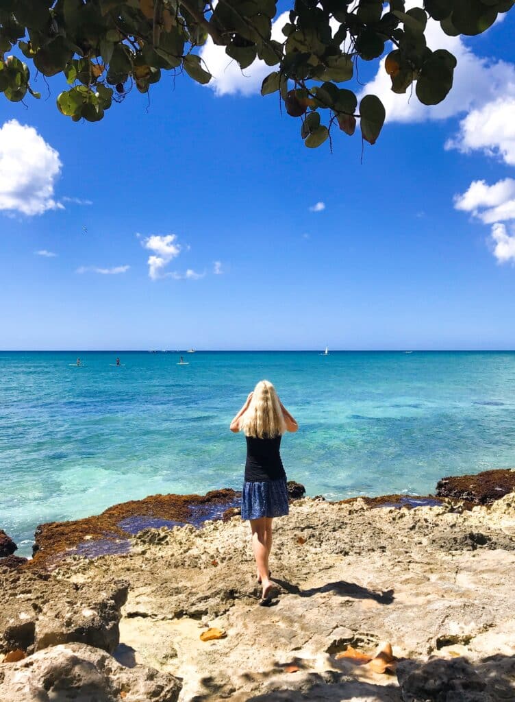Blonde Frau auf einem Strand in der Dominikanischen Republik mit dem Meer im Hintergrund. 