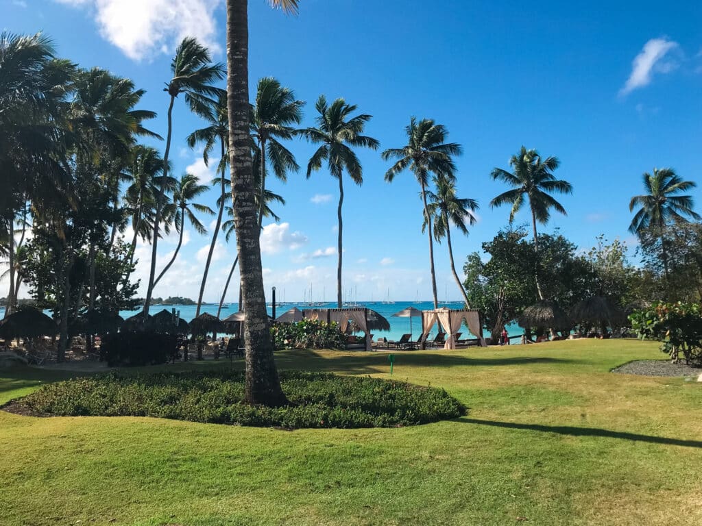 Gartenansicht eines Hotel in der Dominikanischen Republik mit dem türkisen Meer im Hintergrund. 