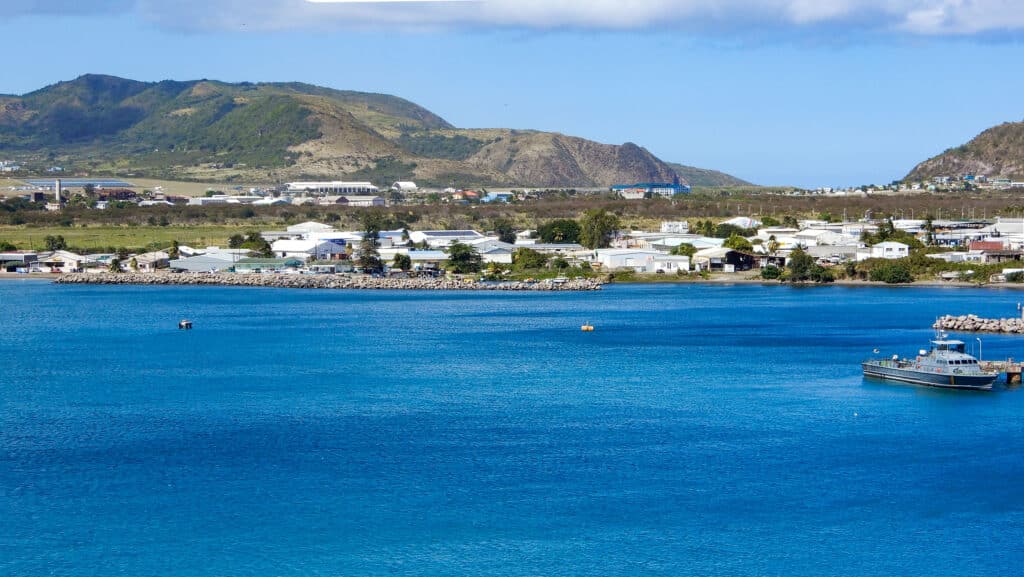 Aussicht vom Kreuzfahrtschiff auf das blaue Meer und die Statt Basseterre, St. Kitts. 